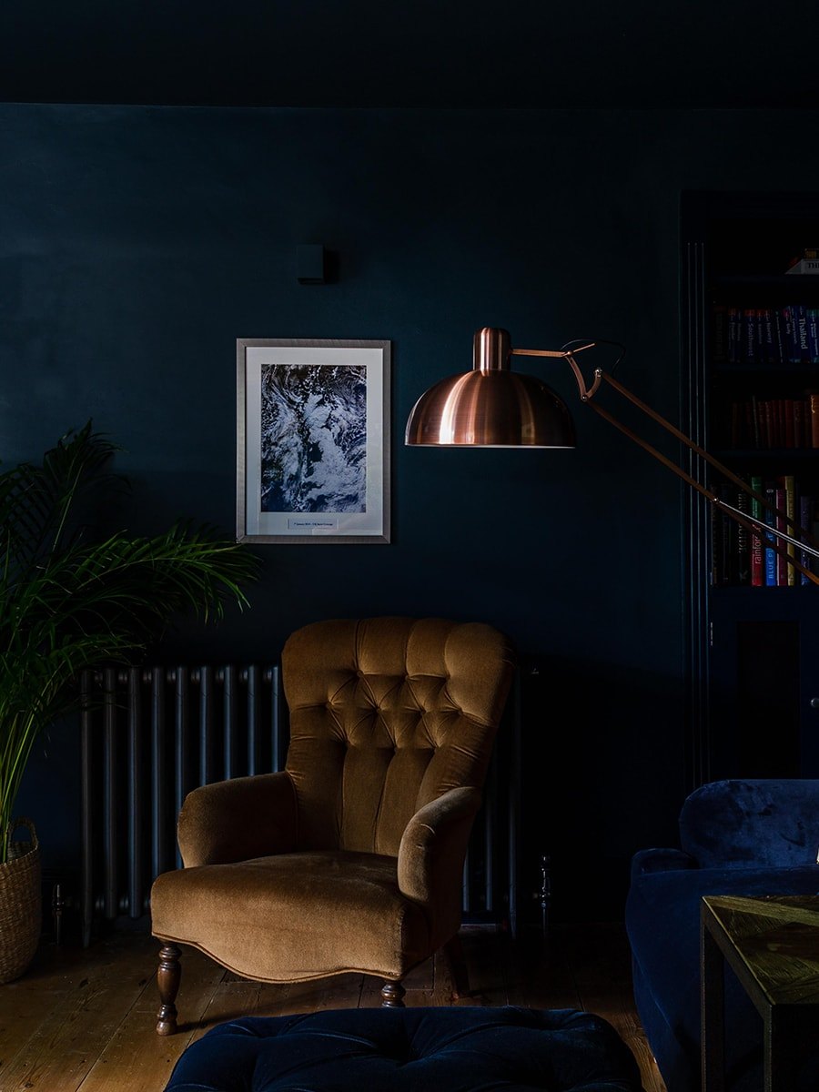 Cambray House moody snug with velvet armchair, copper floor lamp and deep teal walls, Cotswolds